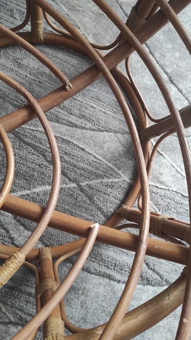 Duży fotel wiklinowy z poduszką.