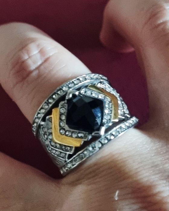 Anel prateado, em aço, com zirconias e uma pedra preta lapidada. T19