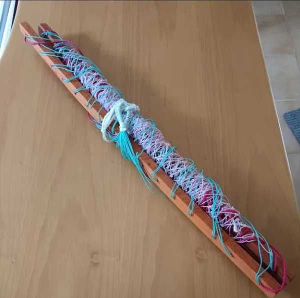 Cama de rede com estrutura em madeira e fios colorido