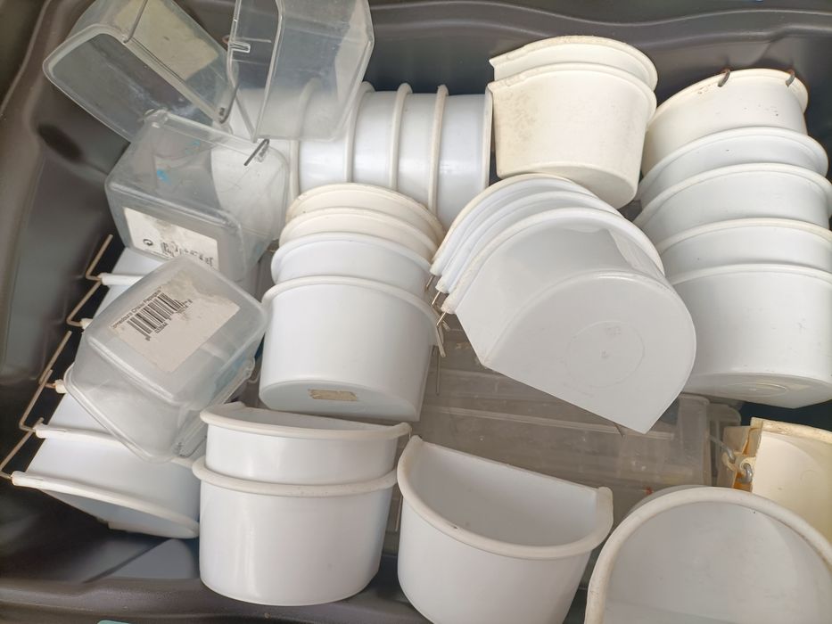 Vários comedouros e  em PVC brancos e transparentes