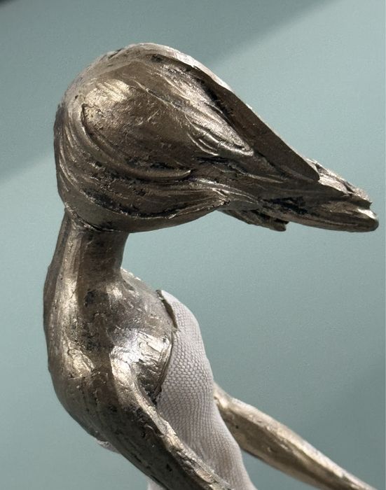 Peça decorativs em formato de mulher com o cabelo a fugir com o vento.