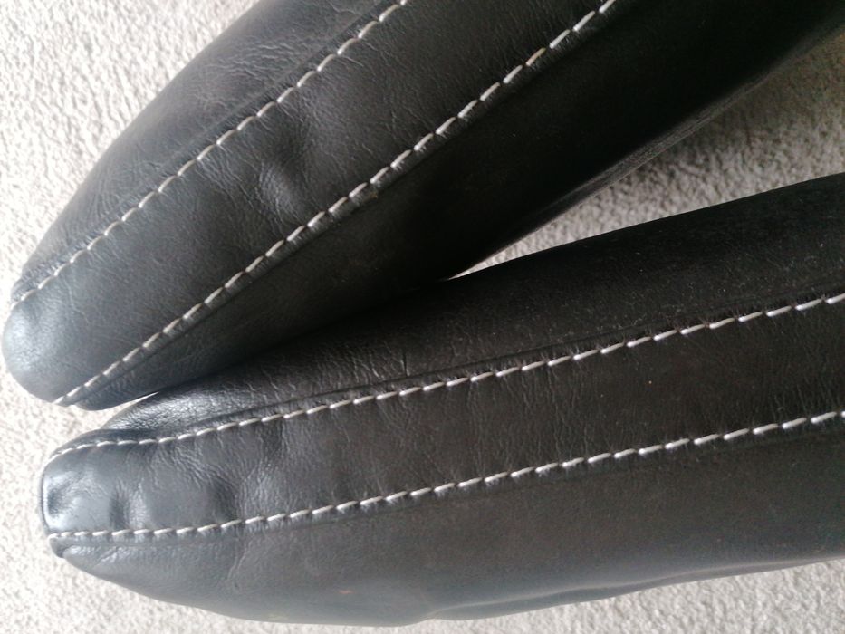 Almofadas em pele castanha com pesponto a branco