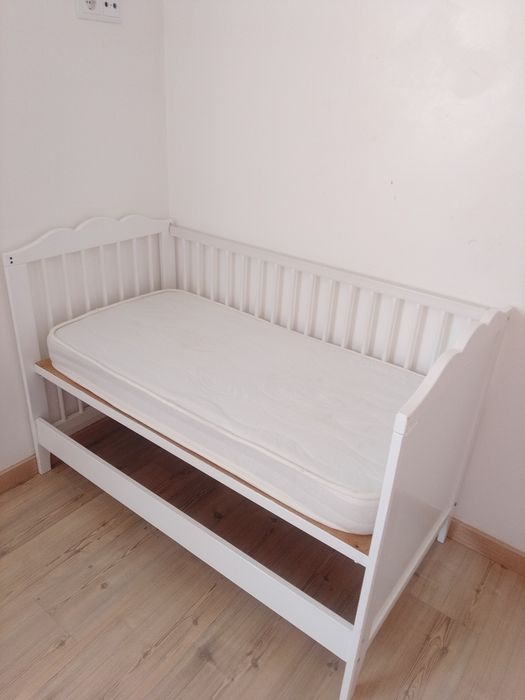 Berço para bebê com colchão.