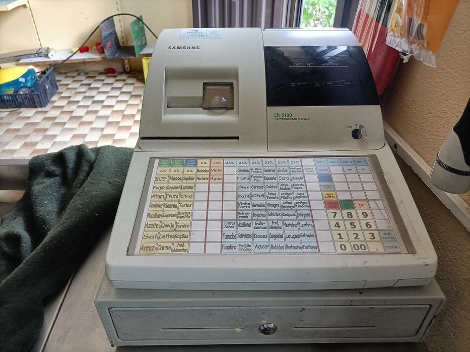 Estante, máquina registradora e máquina de cortar fiambre