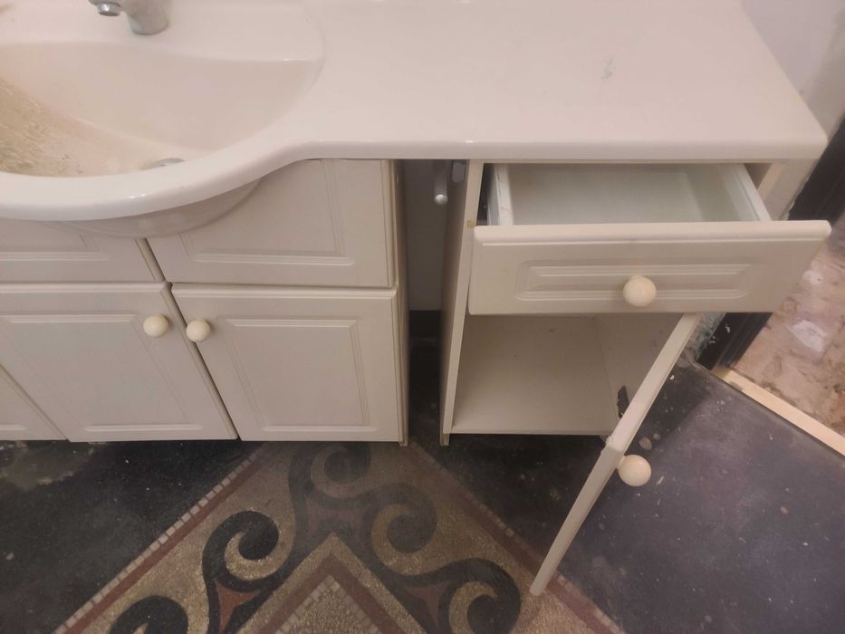 Szafka łazienkowa z umywalka i baterią.