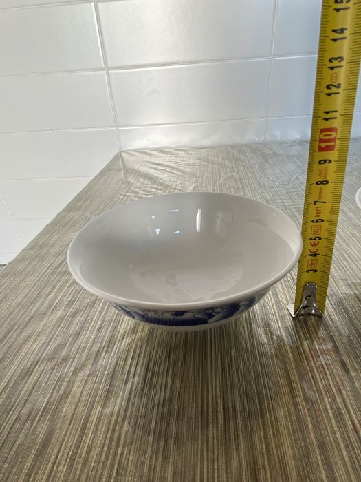 Dois pares de pratos e taças em porcelana azul e branca.