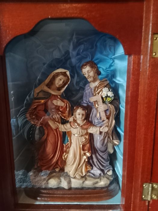 Oratório de Madeira sagrada da família 
Com vidro 

Altura aproximadamente 35cm

Largura aproximadamente 20cm
Com vidro 

Altura aproximadamente 35cm