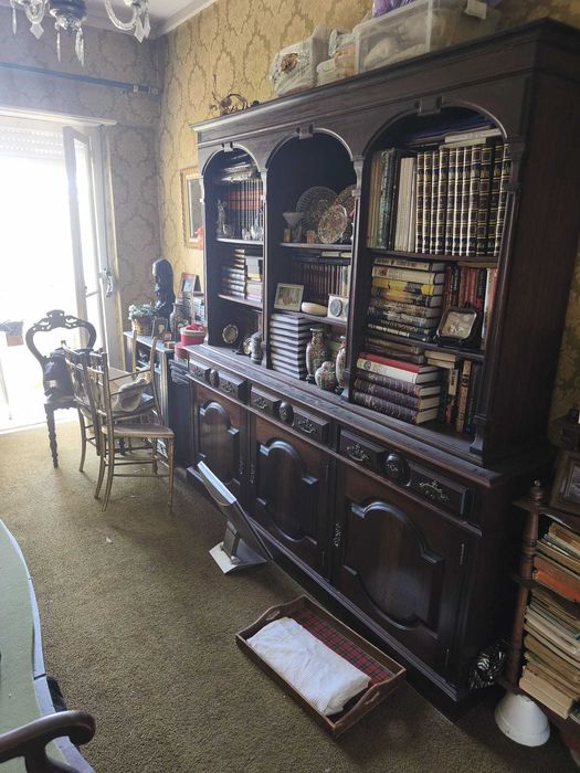 Móvel estante de sala em estilo clássico, fabricado em madeira maciça com acabamento em tom nogueira escuro, em bom estado geral de conservação.