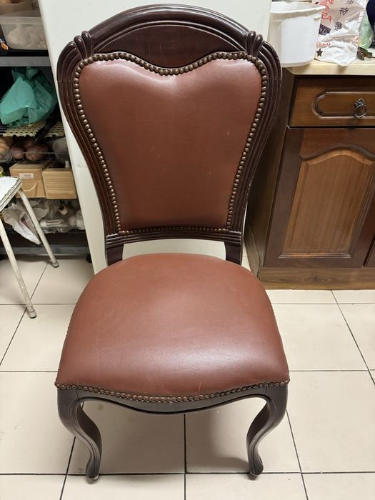 Cadeira vintage em madeira maciça, estilo clássico, com assento e encosto estofados em pele sintética castanha. Muito robusta e em bom estado.