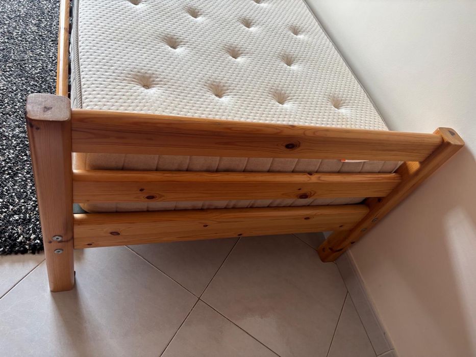 Cama em madeira maciça e colchão.