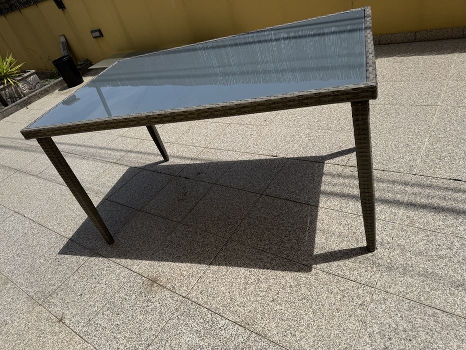 Mesa de jardim em resina trançada com tampo em vidro.