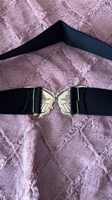 Cinto preto com detalhe de borboleta dourada