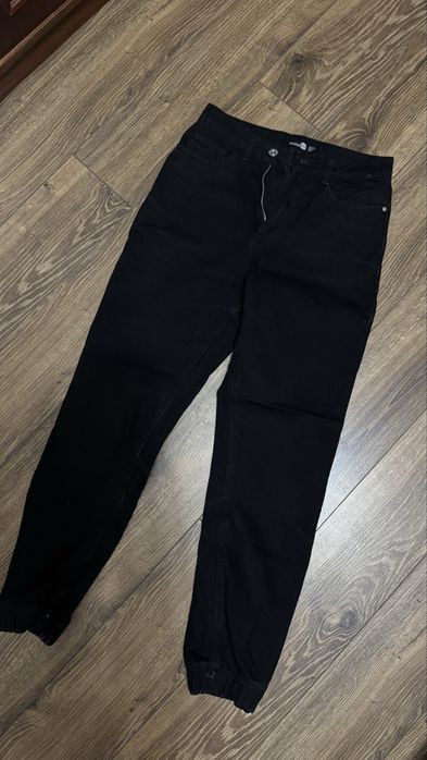 Чорні джинси з манжетами.