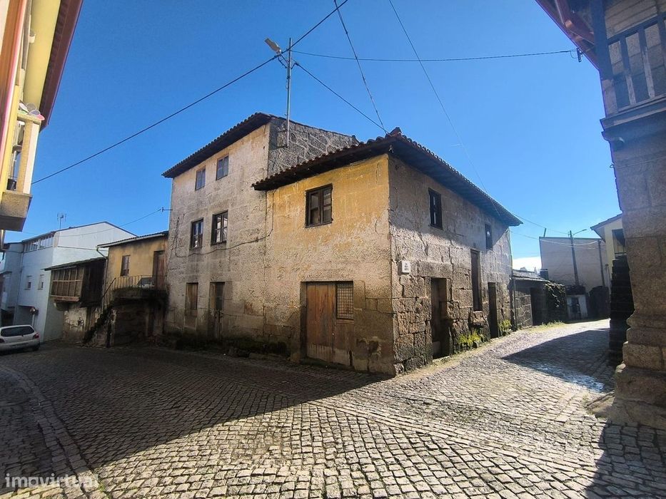 Casa com pátio e garagem para vários carros no centro da aldeia.