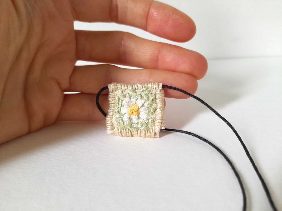 Pulseira bordada à mão com pingente de margarida azul