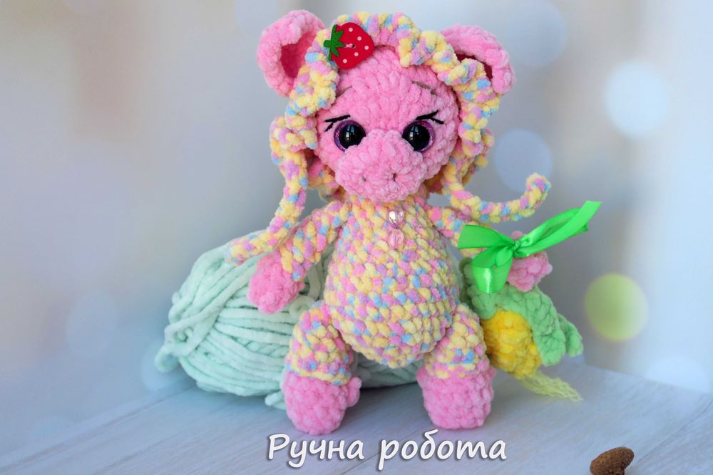 В'язана кольорова свинка в чепчику та з кукурудзою