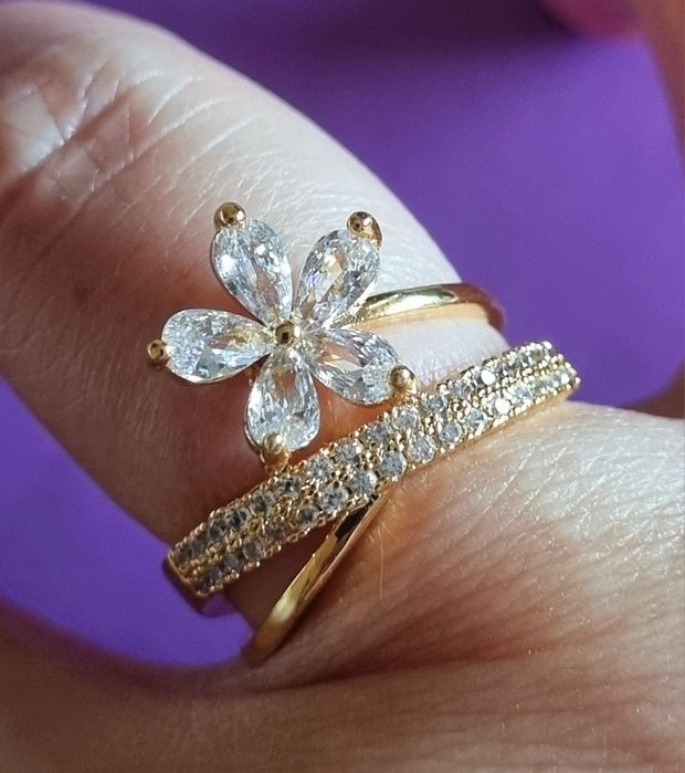 Anel dourado, em aço, com zirconias e uma flor. T17 e T20
