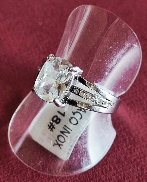 Anel prateado, em aço, com ponto de luz oval e 1 fiada de zirconias.18