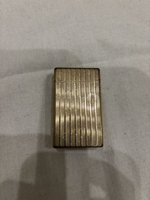 Vendo isqueiro de luxo vintage S.T. Dupont Paris, modelo clássico Ligne 1 com o icónico padrão guilloché de linhas verticais caneladas.