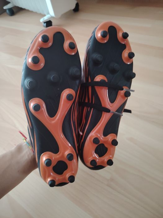 Chuteiras puma pretas e laranja
