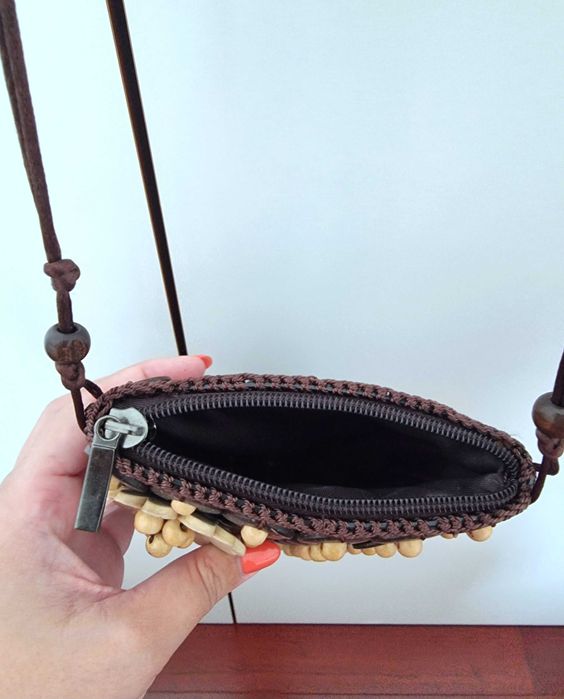 Mala pequena castanha com detalhes e uma flor