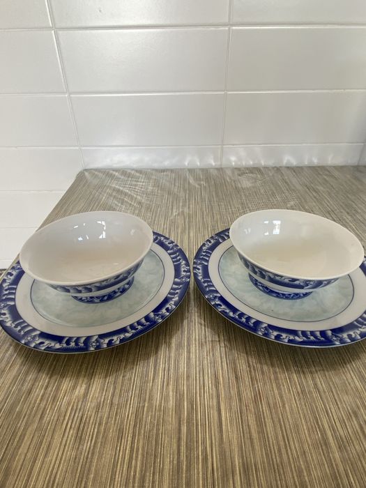 Dois pares de pratos e taças em porcelana azul e branca.