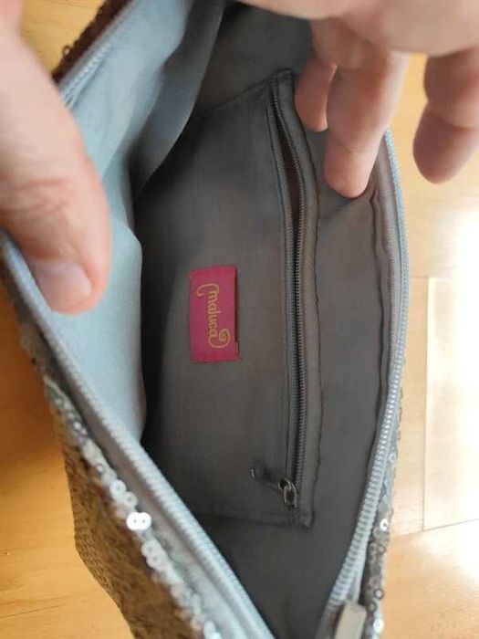 Bolsa de mão prateada com lantejoulas e acabamento em ráfia.