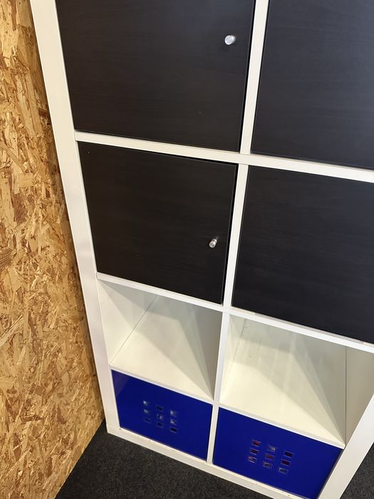 estante branca com portas pretas + caixas azuis em baixo