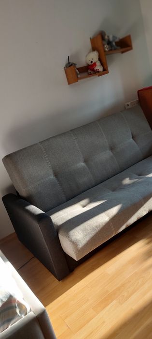 Szara sofa z dwukolorową tapicerką i podłokietnikami