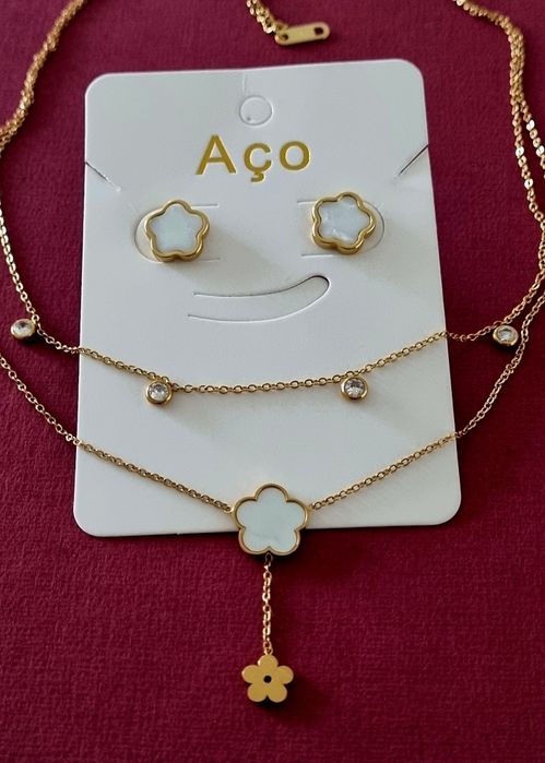 Conjunto dourado (colar duplo e brincos), em aço, com flores brancas em madrepérola.