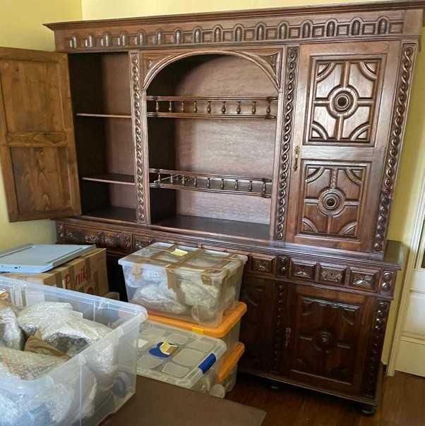 Móvel de sala/jantar antigo com bastante trabalhado (entalhes decorativos, portas almofadadas e prateleiras abertas)