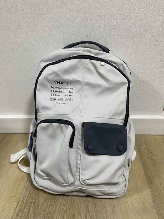 Портфель, білого кольору з сірими елементами.