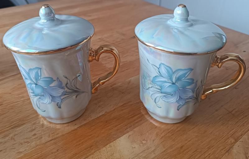 Красива з позолотою та перламутром порцелянова чашка з кришкою на вибі