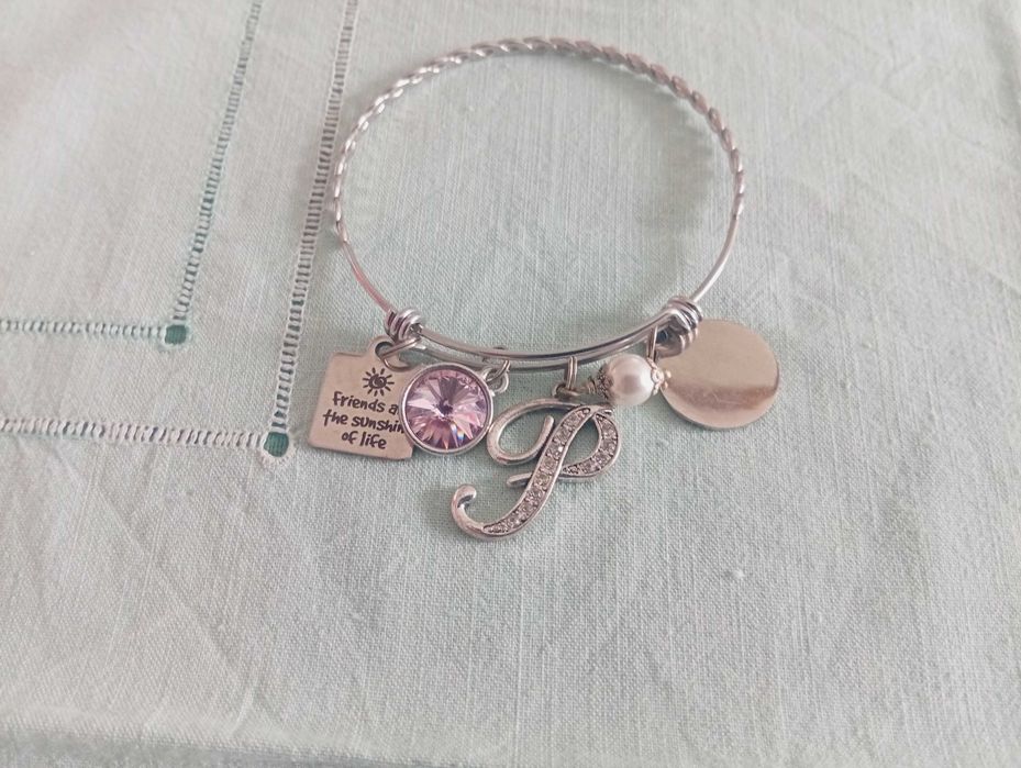 Pulseira em aço inoxidável, com vários berloques temáticos (charm bracelet)