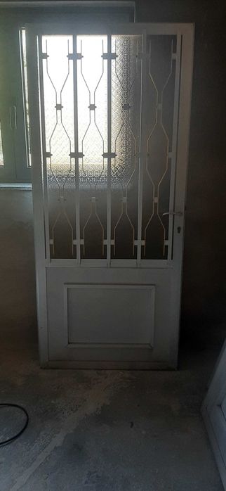 Porta em Metal com Vidro Texturado e Grade de Proteção