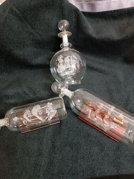 3 garrafas com navios dentro