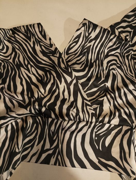 Top em branco e preto, com mangas largas, aperta atrás com um laço,de marca New Feeling, tamanho M