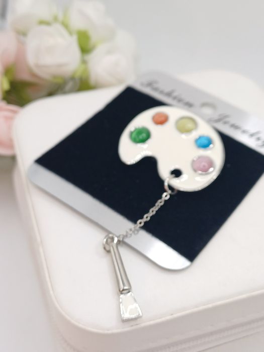 Ozdobna broszka paleta kolorów i pędzel