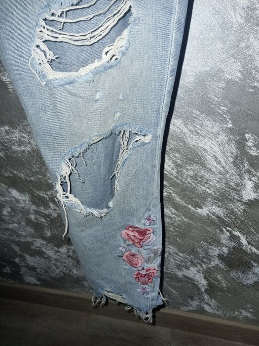 Super dżinsy z rozdarciami haftowanymi kwiatami.