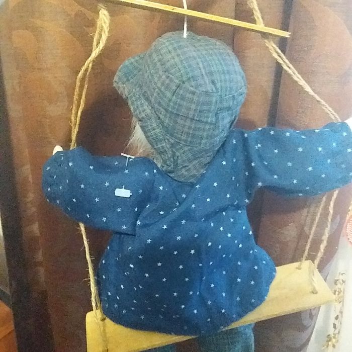 Игрушка клоун на качеле.