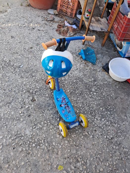 Trotinete de tres rodas e capacete para crianca