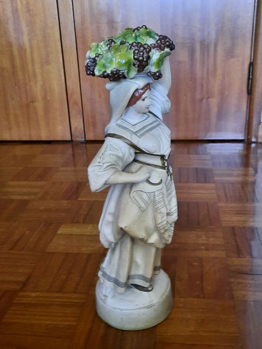 Estatueta decorativa em porcelana - camponesa com cesto de uvas