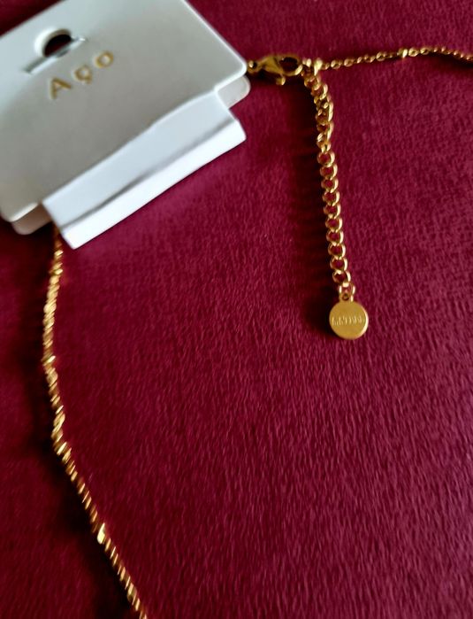 Colar dourado, em aço, malha com bolinhas e pingente borboleta azul.