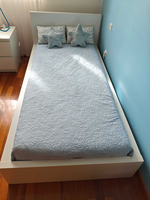 Cama de solteiro com colchão e edredão.