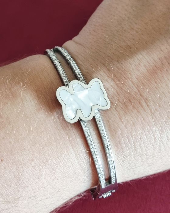 Pulseira/escrava prateada, em aço, com zirconias e um urso em madrepér