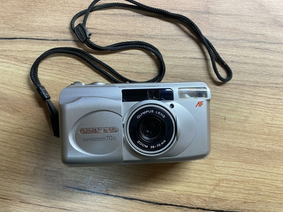 Пленочный фотоаппарат OLYMPUS superzoom 70g у працюючому стані.