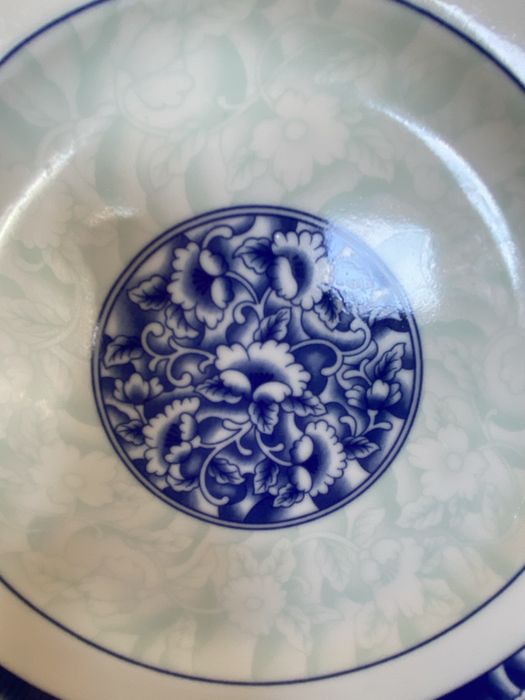 Dois pares de pratos e taças em porcelana azul e branca.