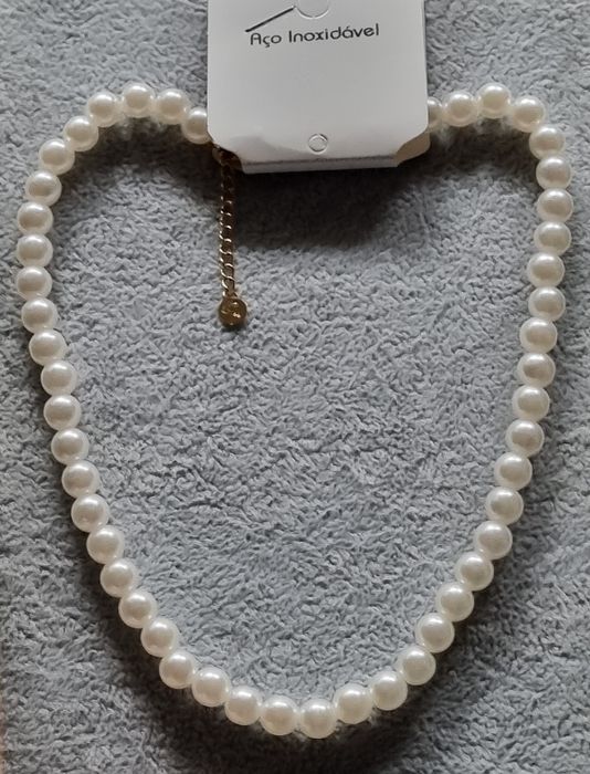 Colar/choker de pérolas com acabamento dourado em açol. Tem extensor