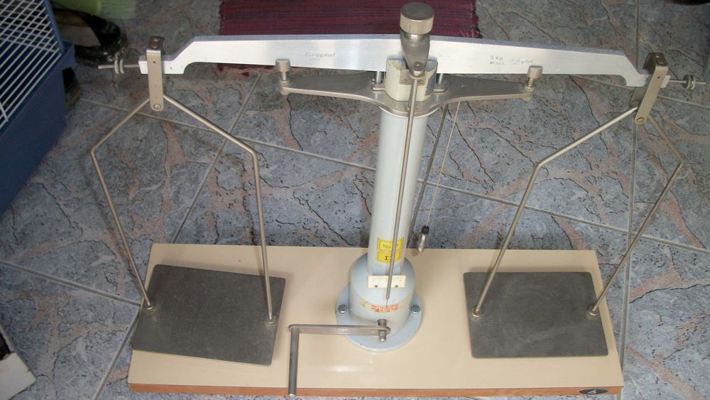 balança metálica com base em madeira