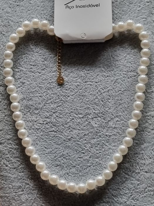 Colar/choker de pérolas com acabamento dourado em açol. Tem extensor